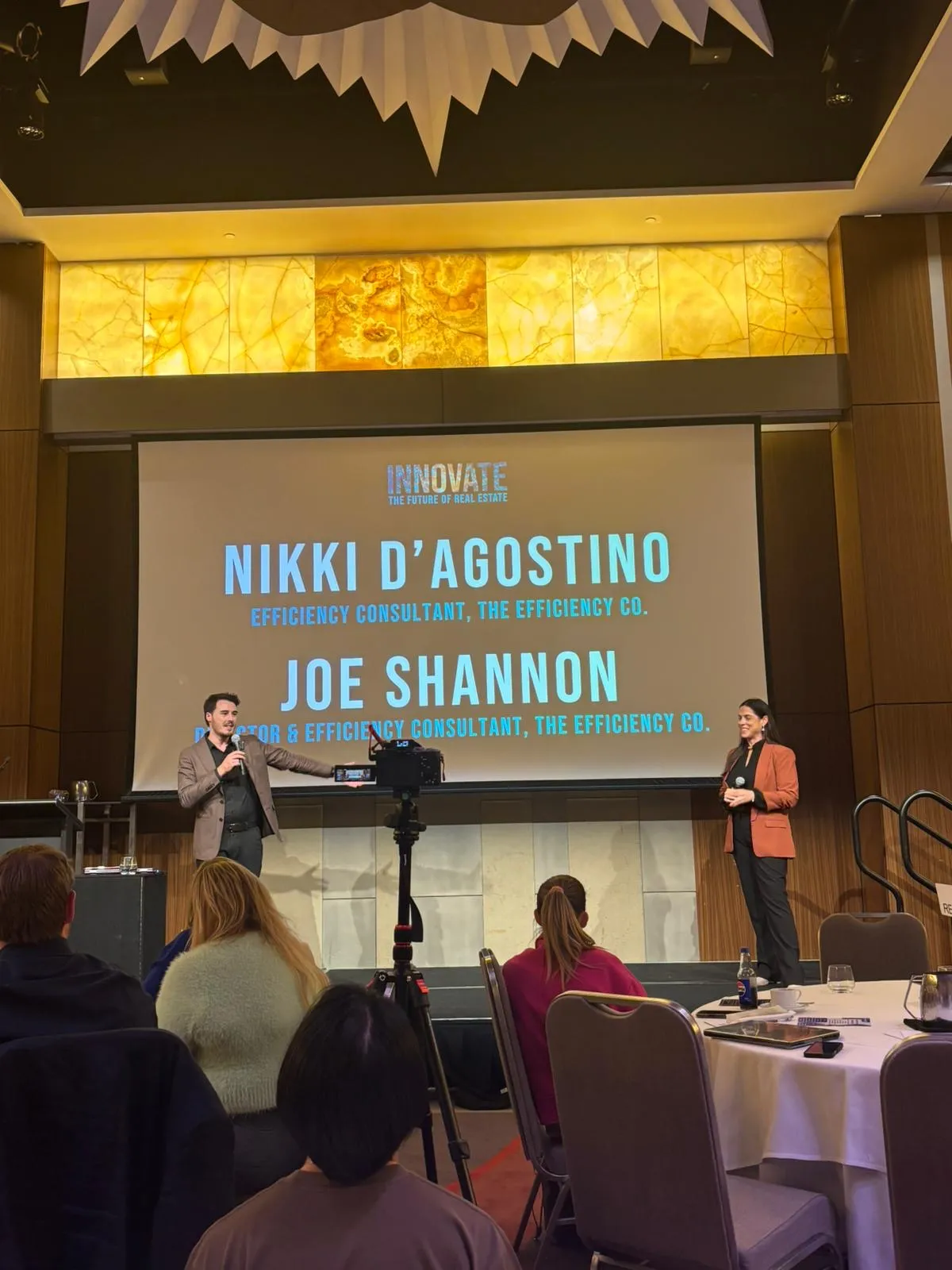 Nikki Mackenzie and Joe Shannon presenting together on stage at REIWA Innovate